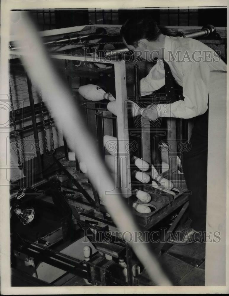 1941 Press Photo D.W.Davis load a magazine with pins after conveyor belt.