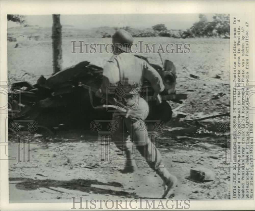1961 Press Photo Tunisian soldier running for cover during air raid, Tunisia