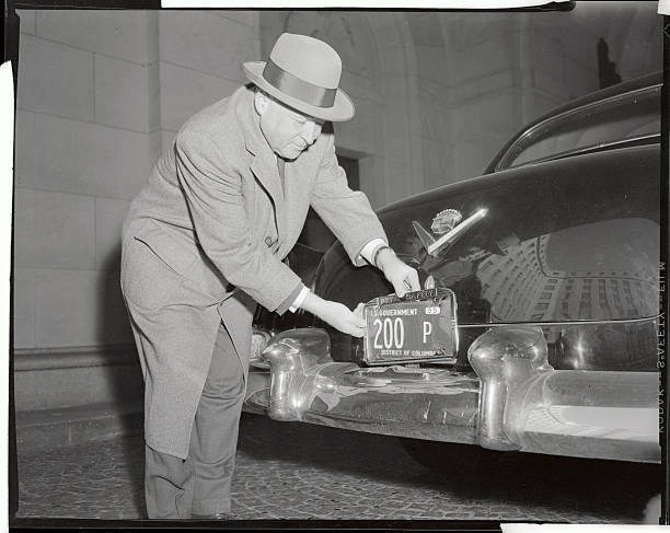 Arthur Summerfield Placing License Frames on His Car 1955 Photo