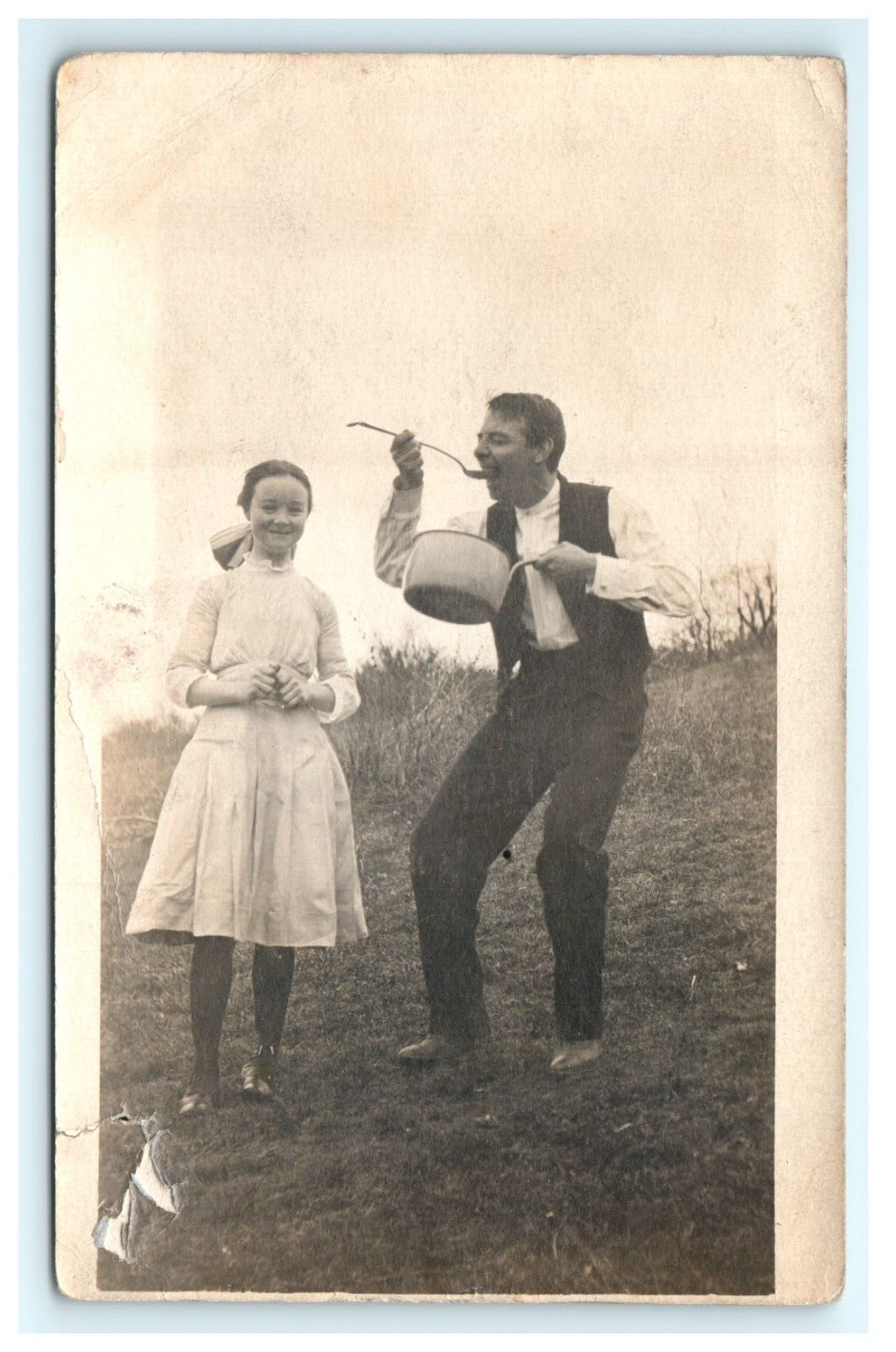 1907-1914 Comical Man Eating out of Pot and Young Girl RPPC Outdoor Postcard