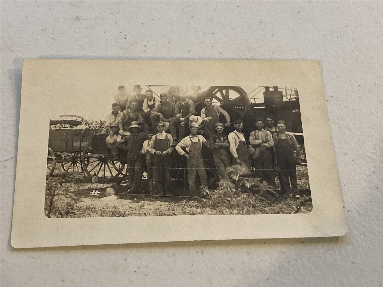 c1910 RPPC group of workers by farm equipment, threshing machine or something