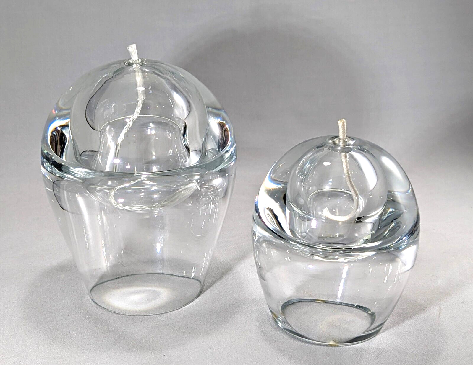 A pair of MCM thick, heavy, clear sphere, oil burning art glass