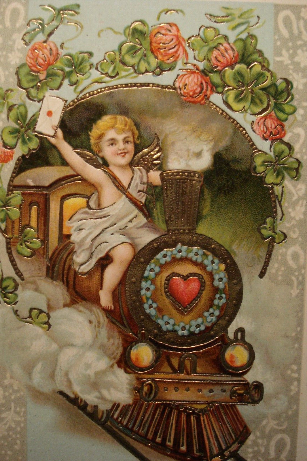 ANTIQUE EMBOSSED BEST WISHES POSTCARD CUPID DRIVING STEAM TRAIN, 4-LEAF CLOVER
