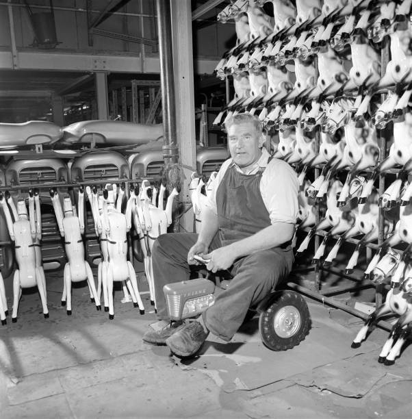 Man sitting on toy tractor Tri-ang factory Merton South London 1965 Old Photo 2