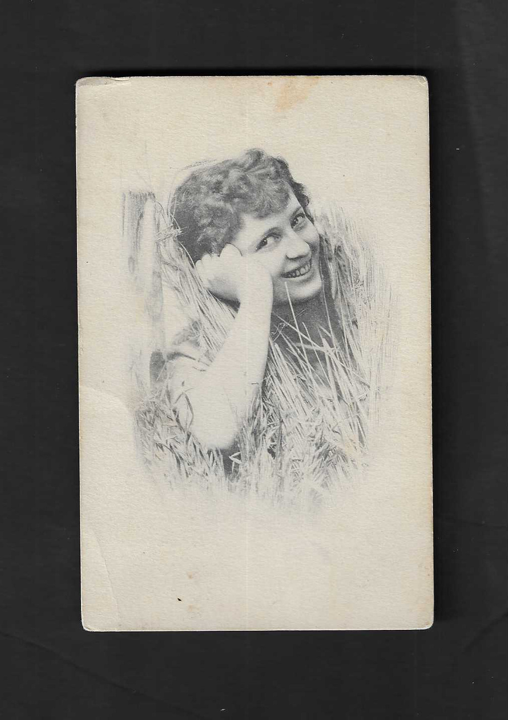 Mar. 1912 real photo postcard laugh lady lying in hay field