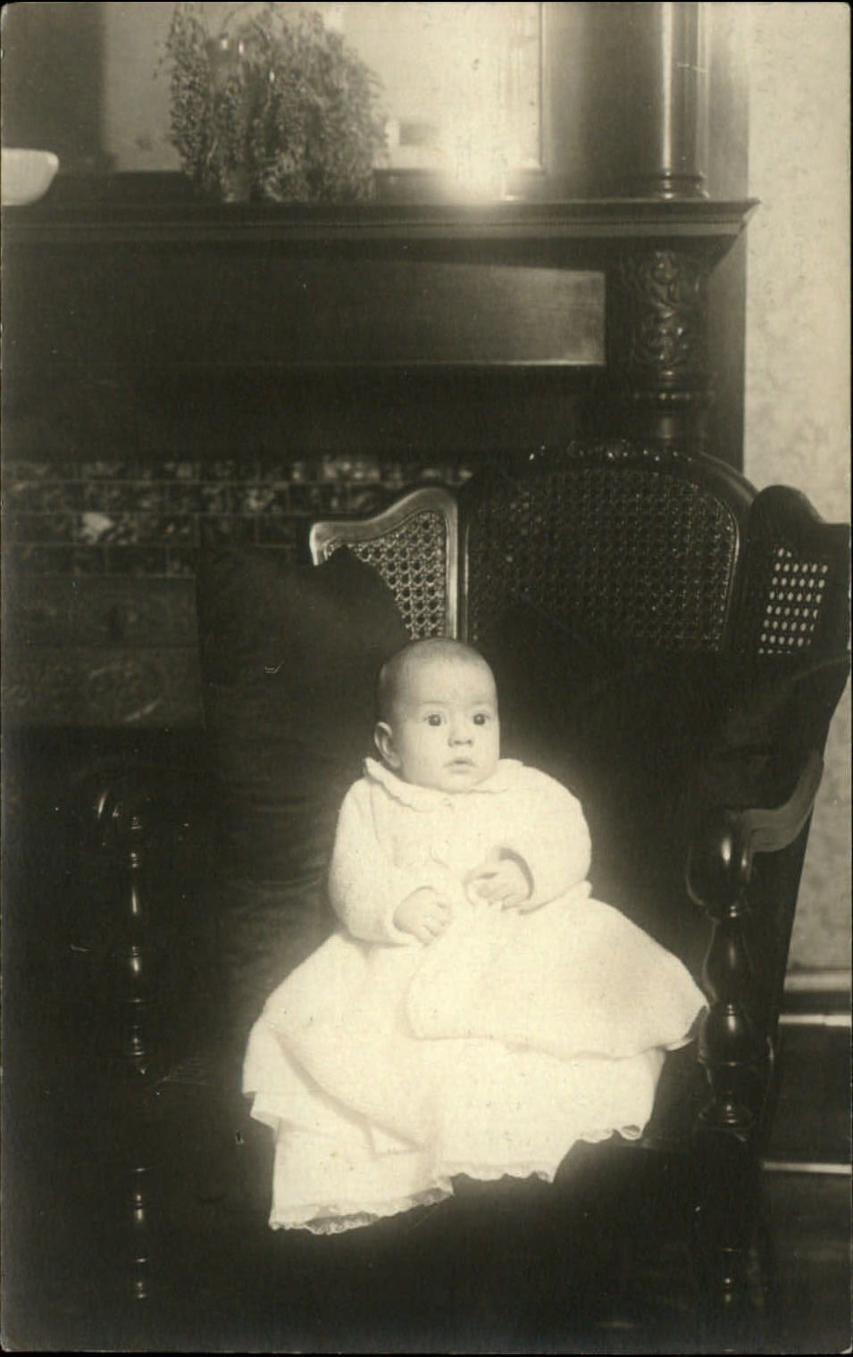 RPPC ~ Wide-eyed baby on cane-back chair ~ real photo postcard