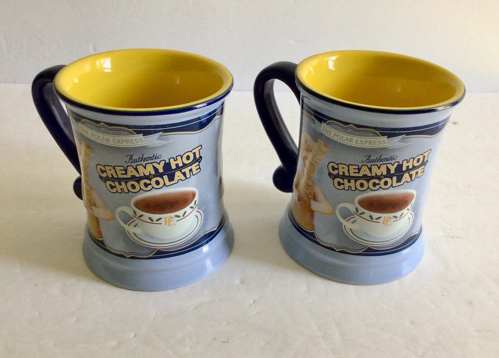 2 Polar Express Creamy Hot Chocolate Mugs Embossed Yellow Interior Pale Blue