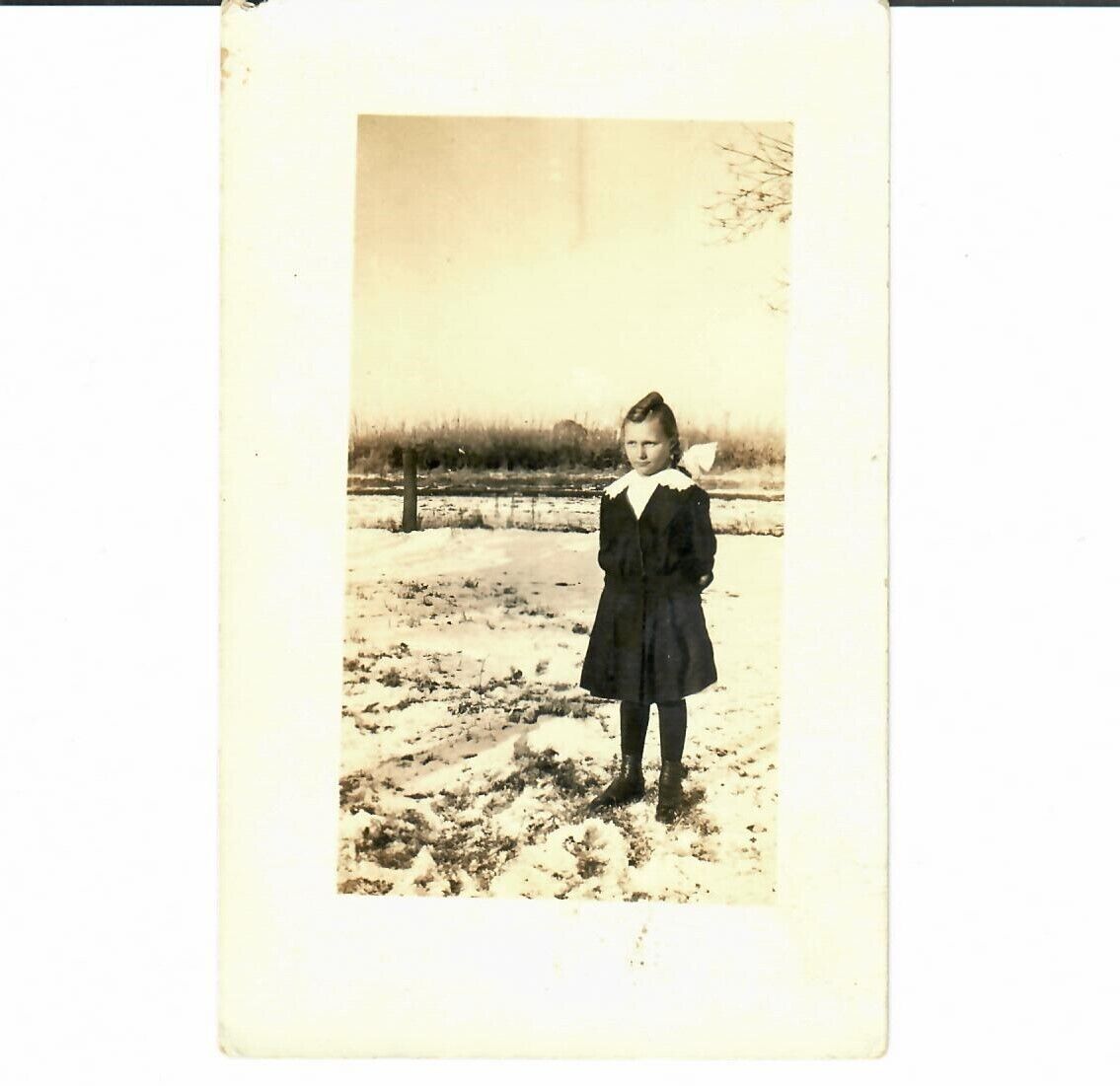 RPPC Child Girl Standing in snowy yard Hair Bow Antique Divided Back AAZO