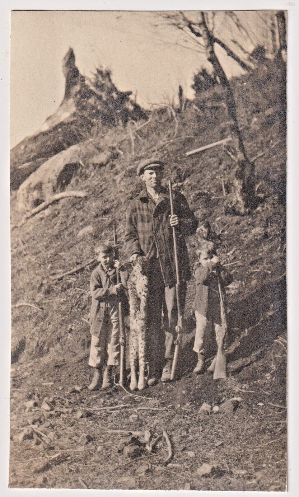c 1912 RPPC Man & Sons Hunting Rifles Posing with Caught Bobcat nr Valdez Alaska