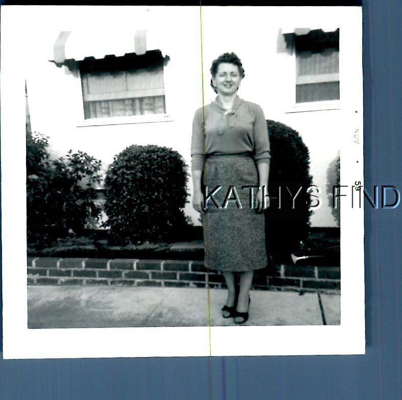 FOUND B&W PHOTO E+4415 PRETTY WOMAN IN DRESS POSED BY HOUSE