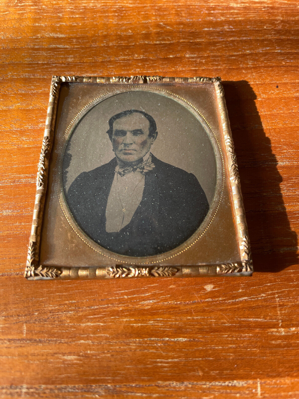 Early 1/6th size Tintype vignette of young man in brass mat/frame