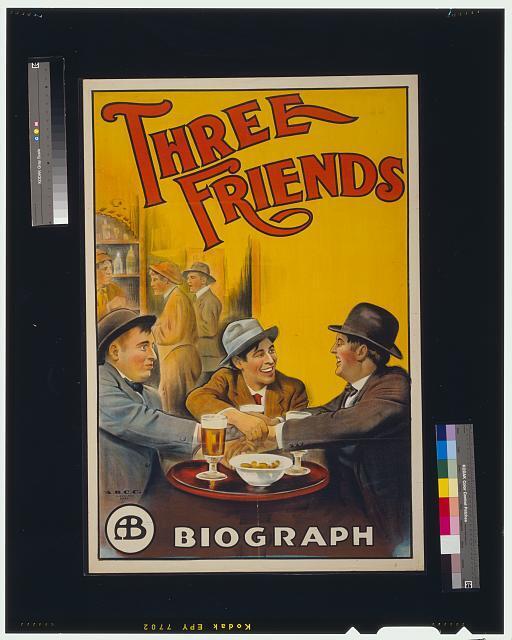 Three friends,three men clasping hands while sitting at table,1913,film poster