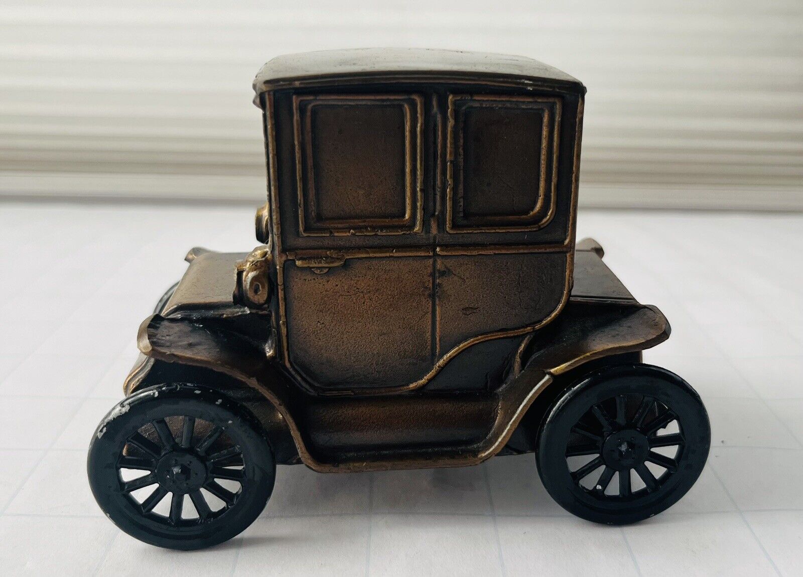 Antique Baker Electric Cast Bronze Car Coin Bank With Rolling Wheels.