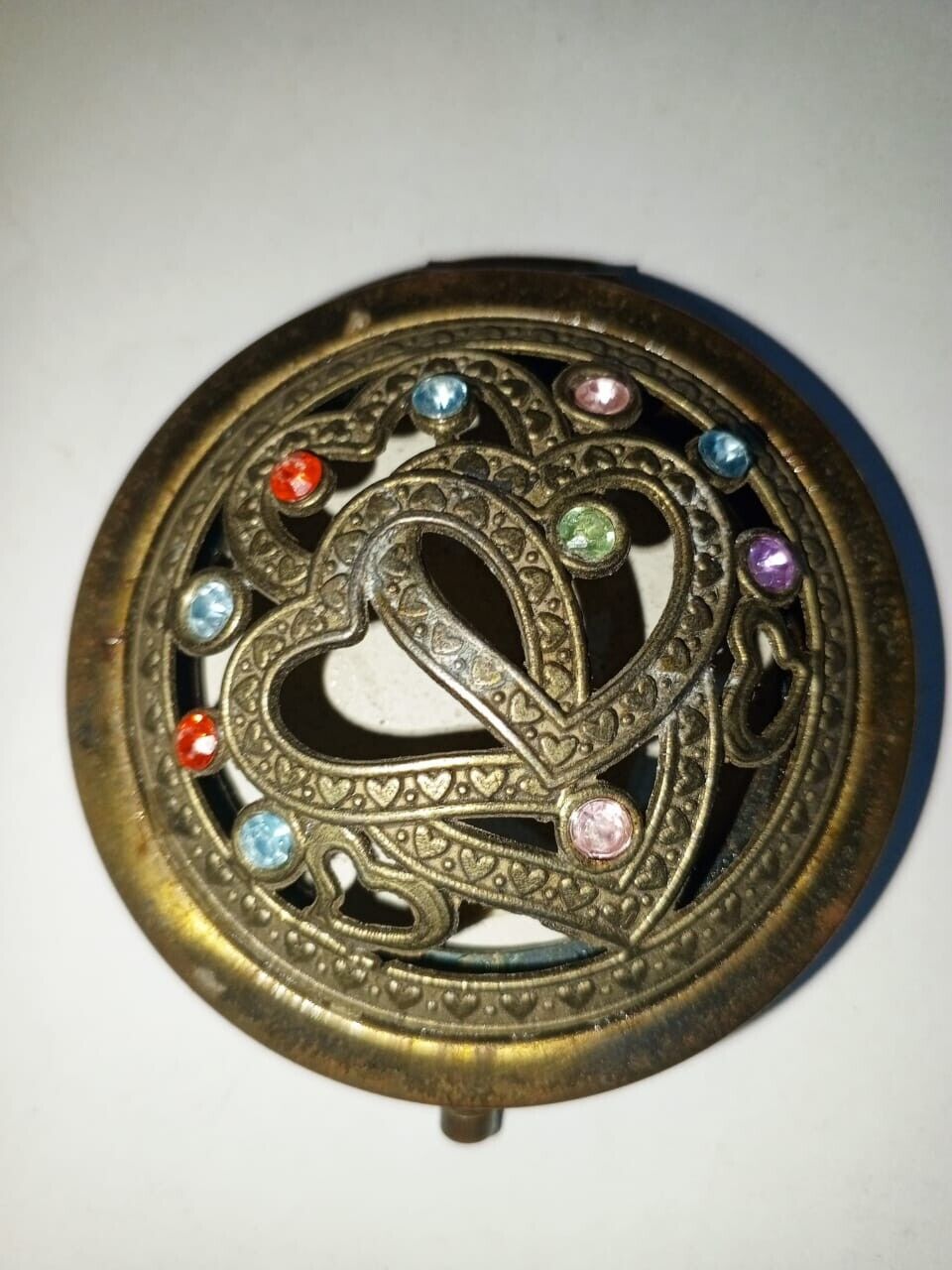 A very old antique brass hand mirror embroidered with natural stones