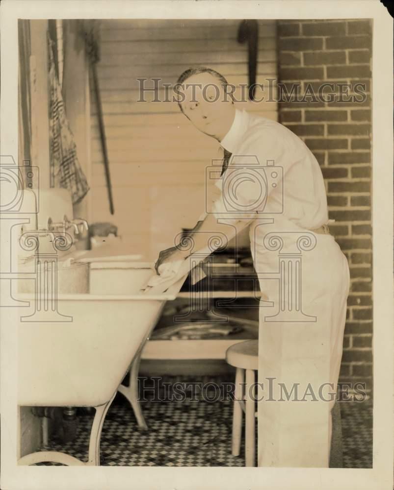 Press Photo Comedic actor Ben Turpin scrubs laundry on a washboard at home