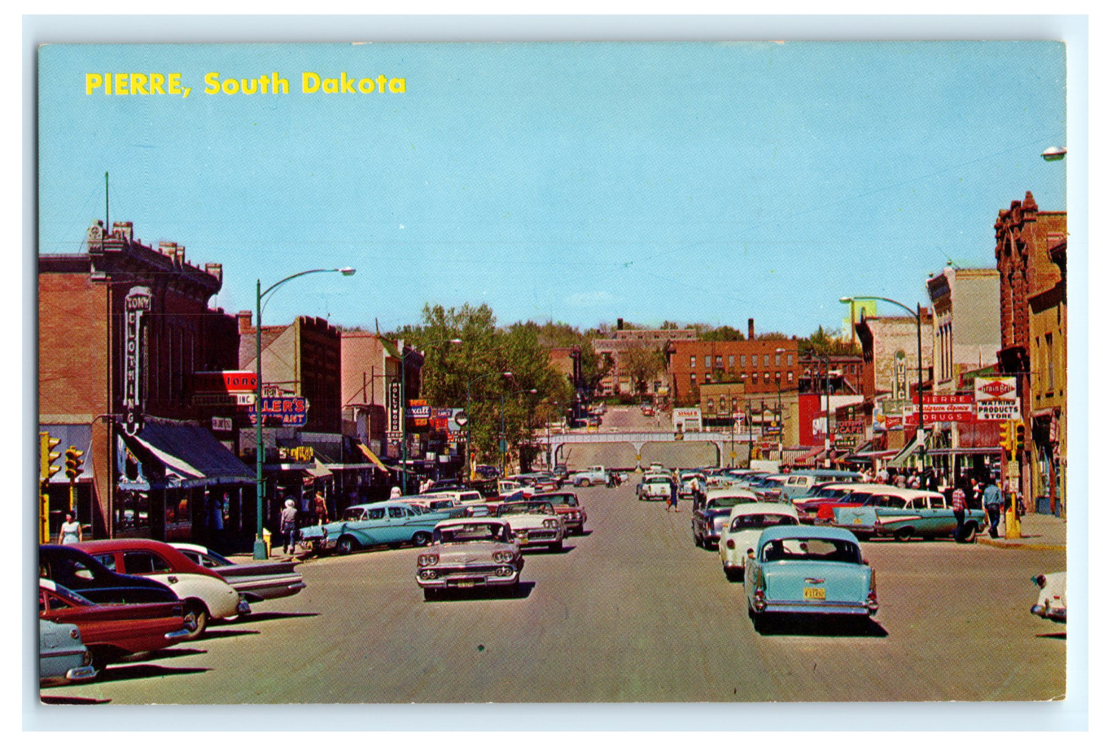 Postcard SD Pierre Busy Main Street View 1950\'s Cars Storefronts Signs Rexall