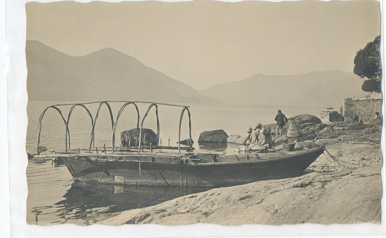 BOAT DOCKED ON BEACH - PEOPLE IN BACKGROUND postcard
