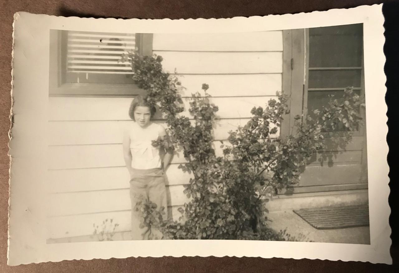 Photo young little girl posing next to Roses by house Cute kid