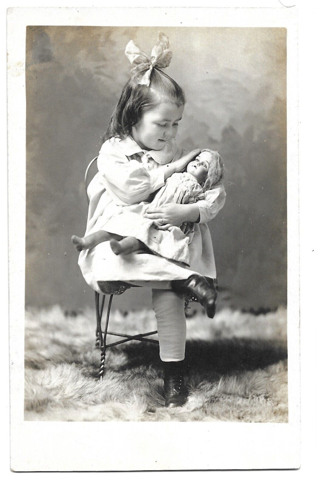 Girl Lovingly Holding Doll In Studio, Antique RPPC Photo Postcard