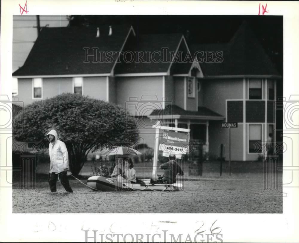 1989 Press Photo Family rafts its way out of Ormond subdivision during flooding
