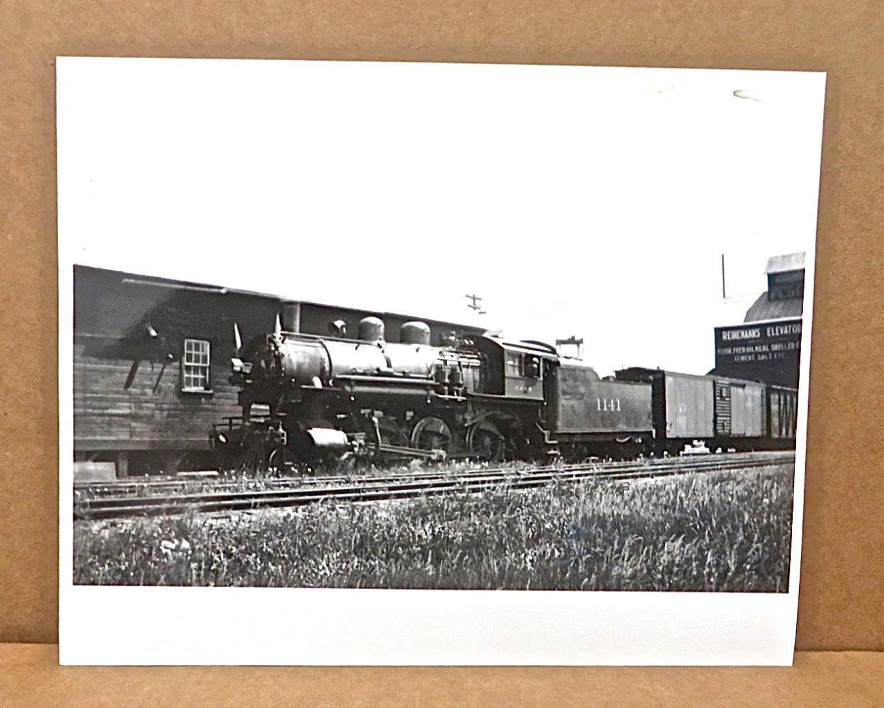 Photo: 1937 C&NW #1141 R-1 Type 4-6-0 With White Flags Extra At Grain Elevator