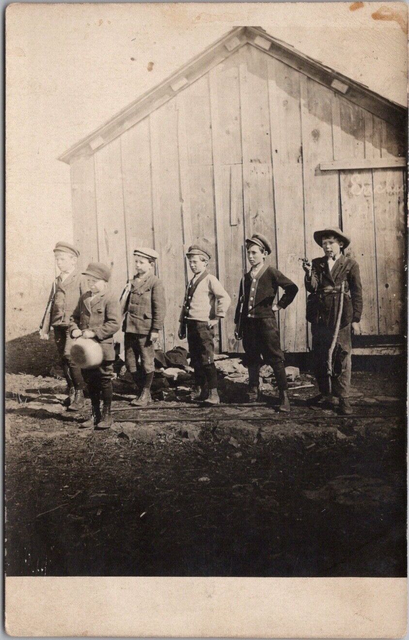 c1910s Real Photo RPPC Postcard Six Boys on Side of Building / Toy Guns & Rifles
