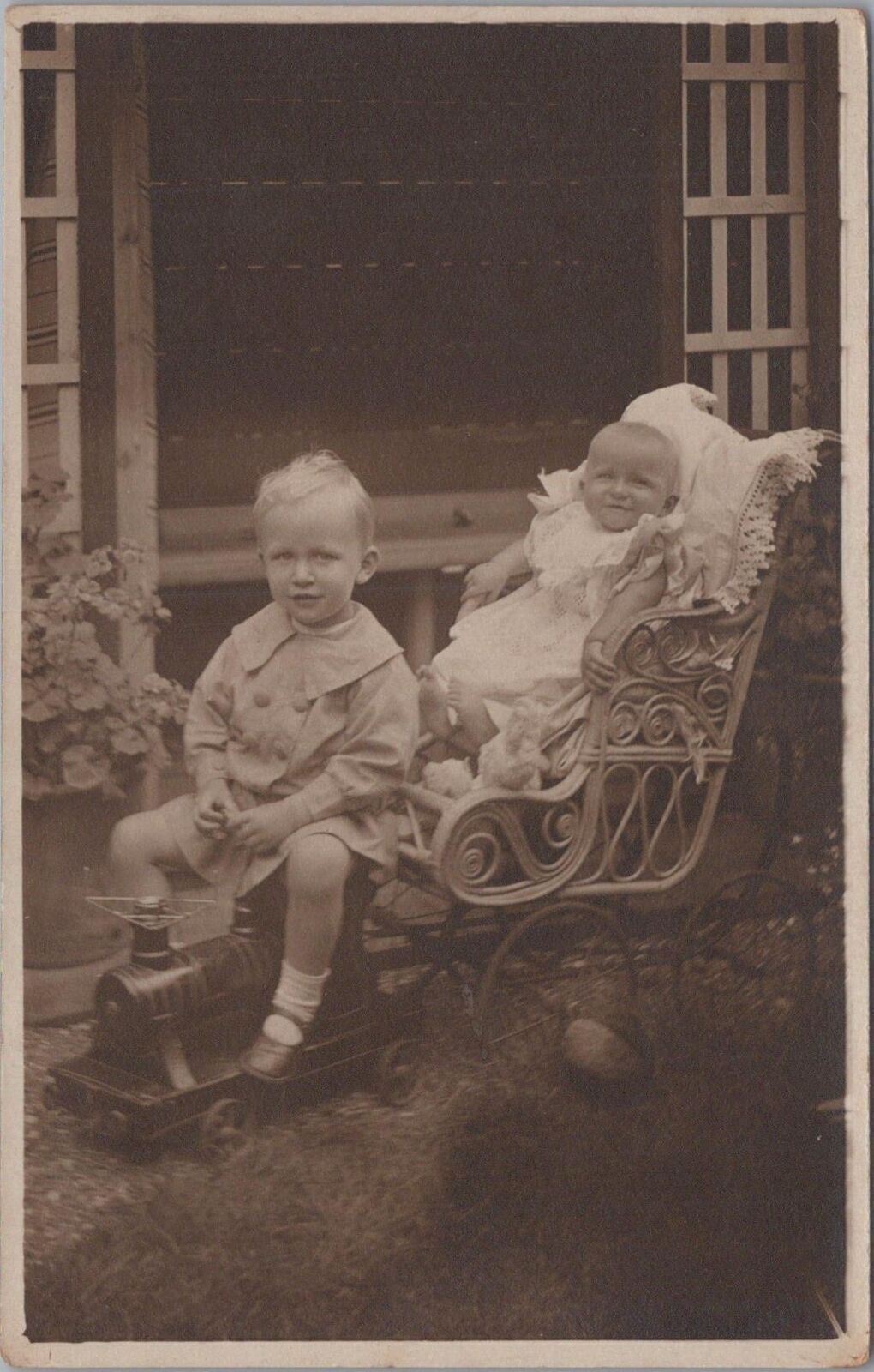 RPPC Postcard Little Boy Riding Toy Train with Baby 