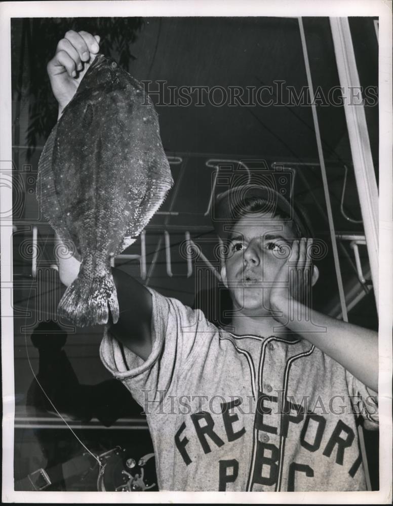 1950 Press Photo Phillip Roberts, 15, look at his prize 4 lb fluke fish