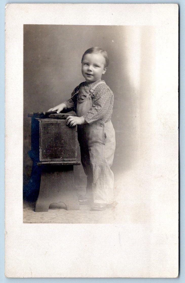 1907-1918 ERA RPPC SMILING CHILD IN OVERALLS*HANDS ON BOX PROP*AZO STAMP BOX