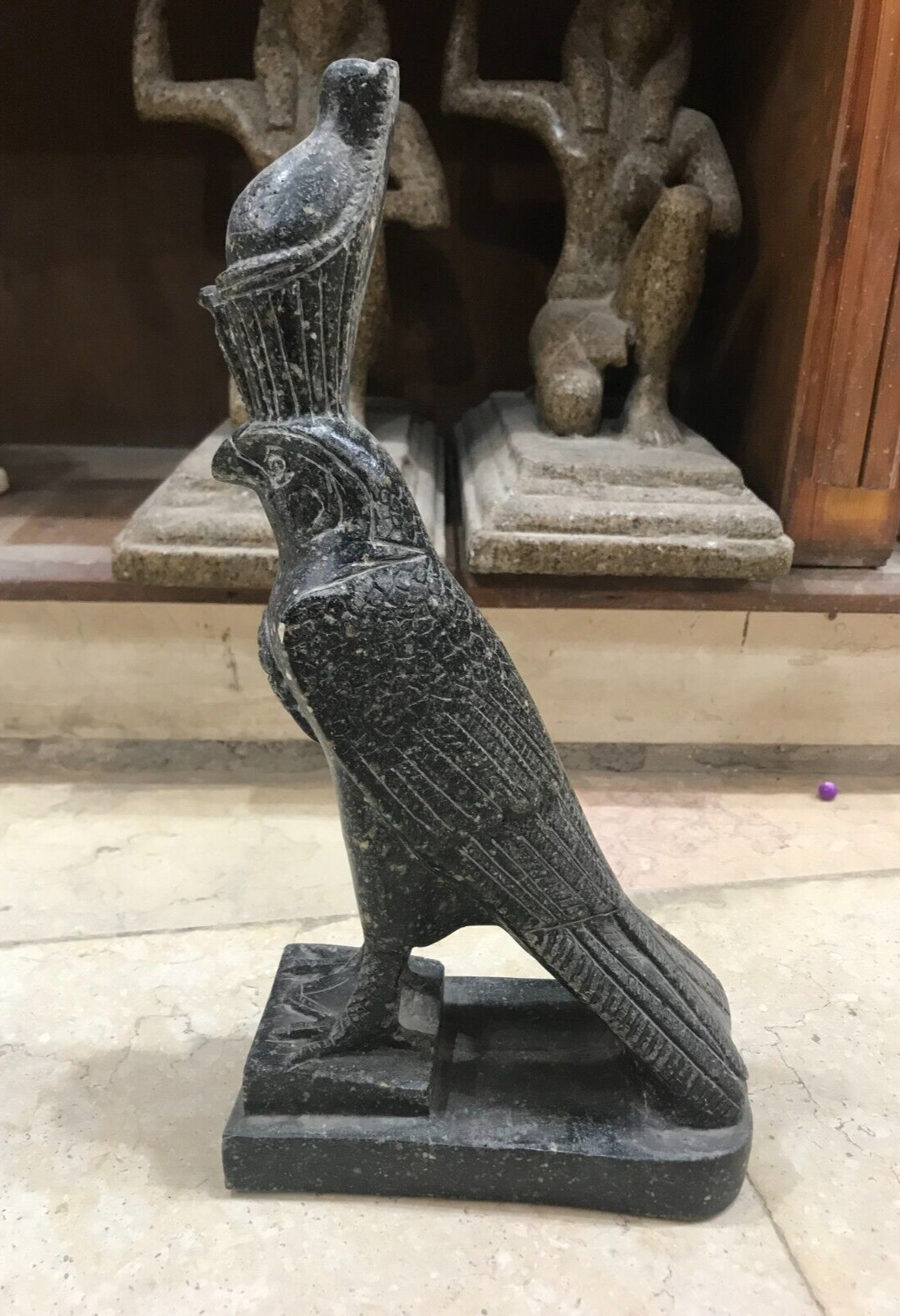 An ancient statue of the god Horus, heavy with a crown made of solid material