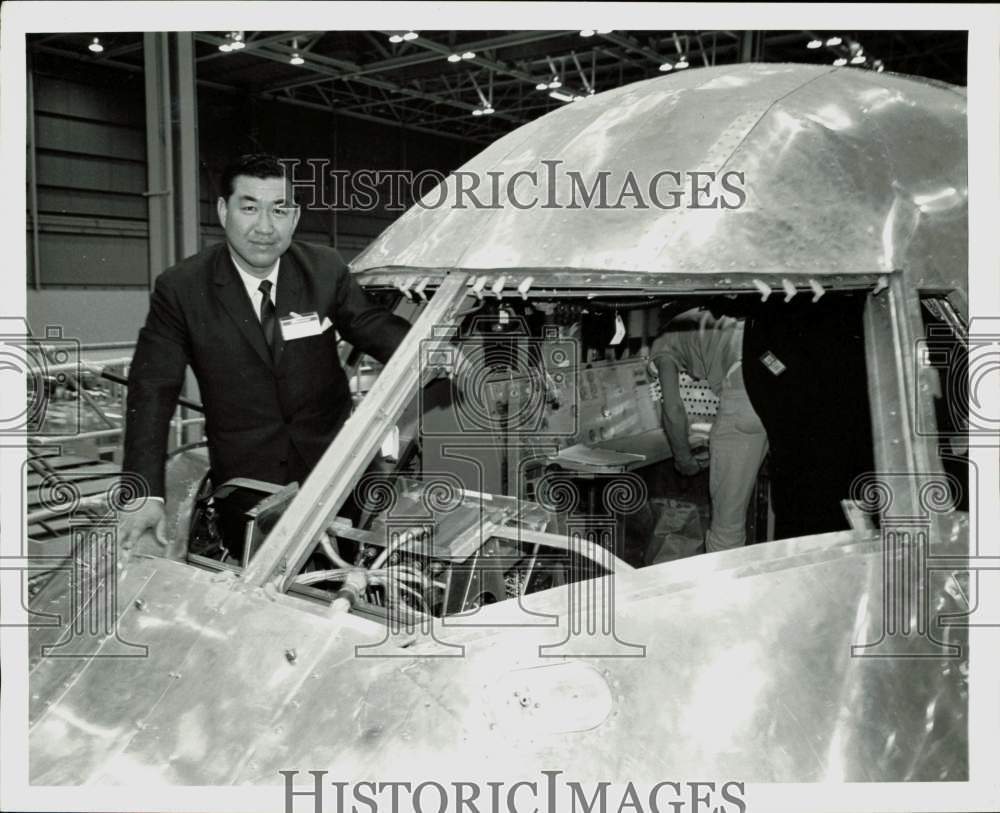 1968 Press Photo An official inspects the cockpit of a plane at plant