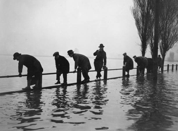 men balancing fence Lea Bridge Road, Essex, during 4 foot flood 1928 Old Photo