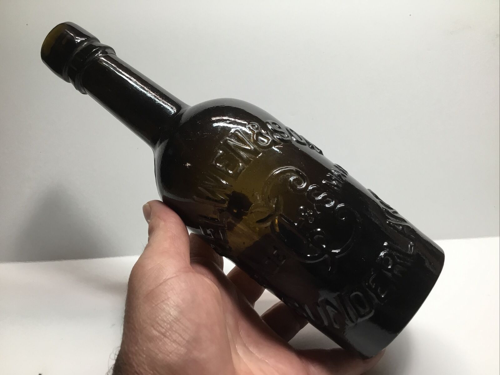 Antique T. Elwen & Son Olive Amber Applied Top Trademark Beer Bottle.