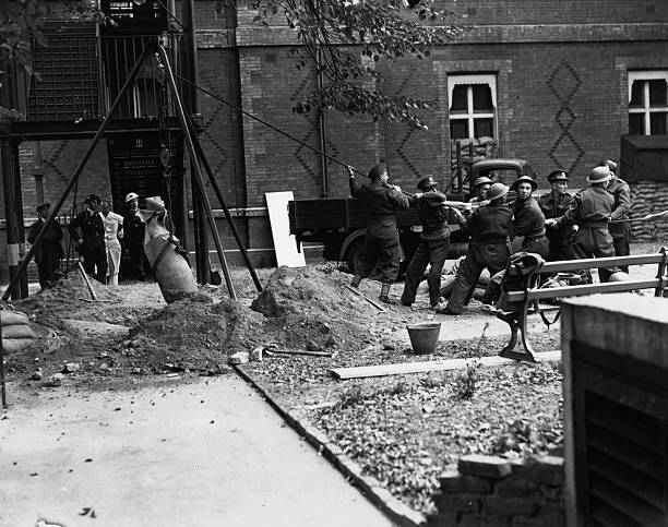 the Bomb Disposal Unit lift a time bomb from the grounds of - 1940 Old Photo 1