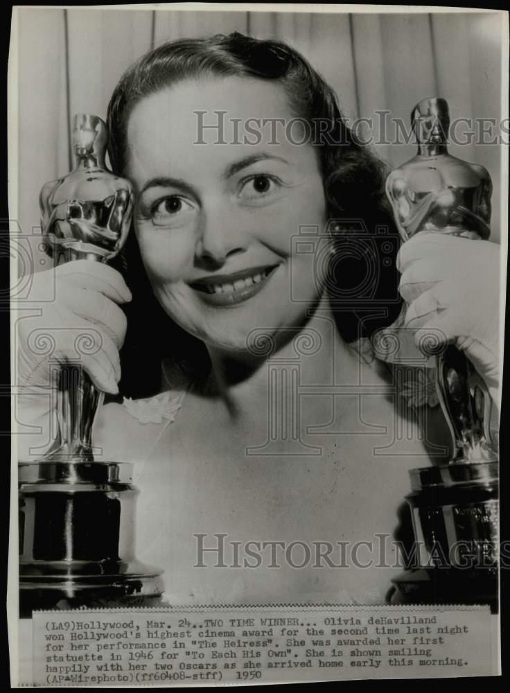 1950 Press Photo Olivia de Havilland holds her two Oscars at her Hollywood home.