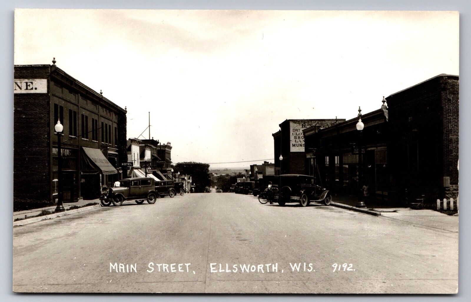 C.1940 RPPC ELLSWORTH, WI, MAIN STREET AT C.1920 BAKERY HOTEL Postcard P39