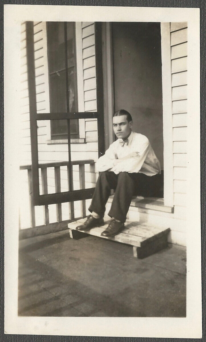 Stern Young Man in Bowtie Sits in Screen Porch Door Vintage 1920s Snapshot