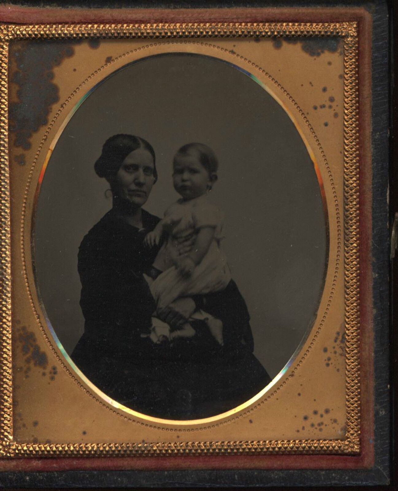 Mother holding toddler sixth-plate ambrotype in clasped case