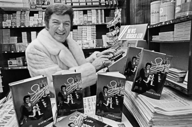 Liberace with copies of his autobiography at news kiosk OLD PHOTO