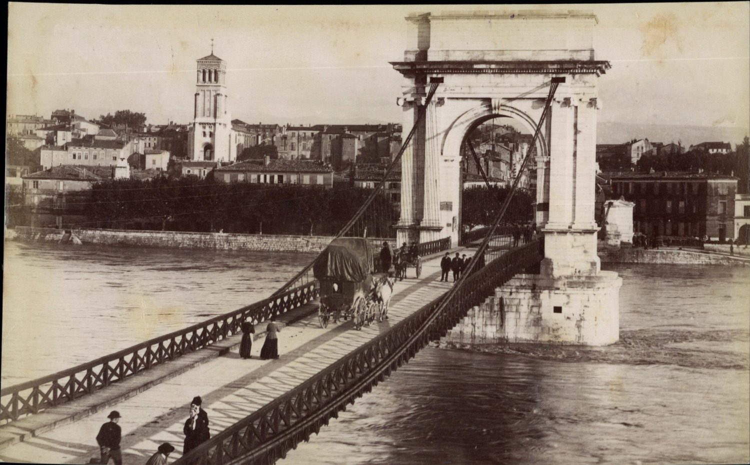 Valencia, carriages and walkers on the suspension bridge, facing the Holy Cathedral