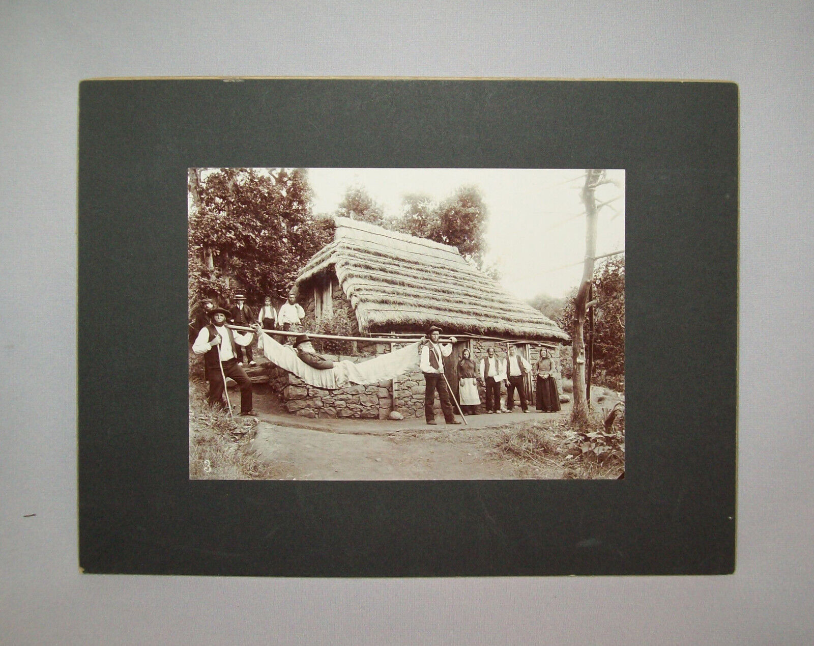 Antique Vtg C 1890s Mounted Photo 11X14 Man in Stretcher Thatched Roof Bare Feet