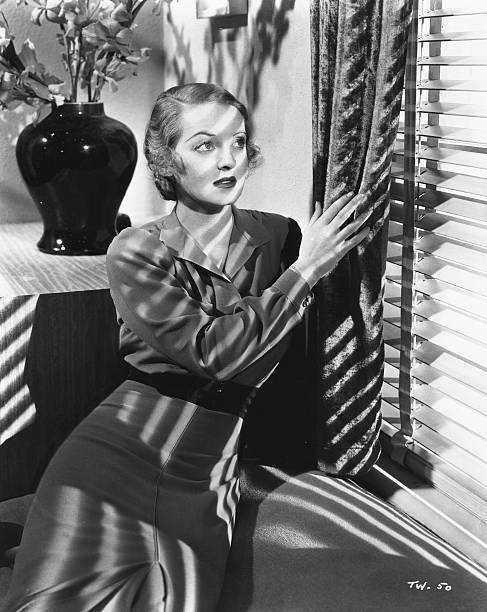 Bette Davis peering through a set of window blinds, in a scene - 1932 Old Photo