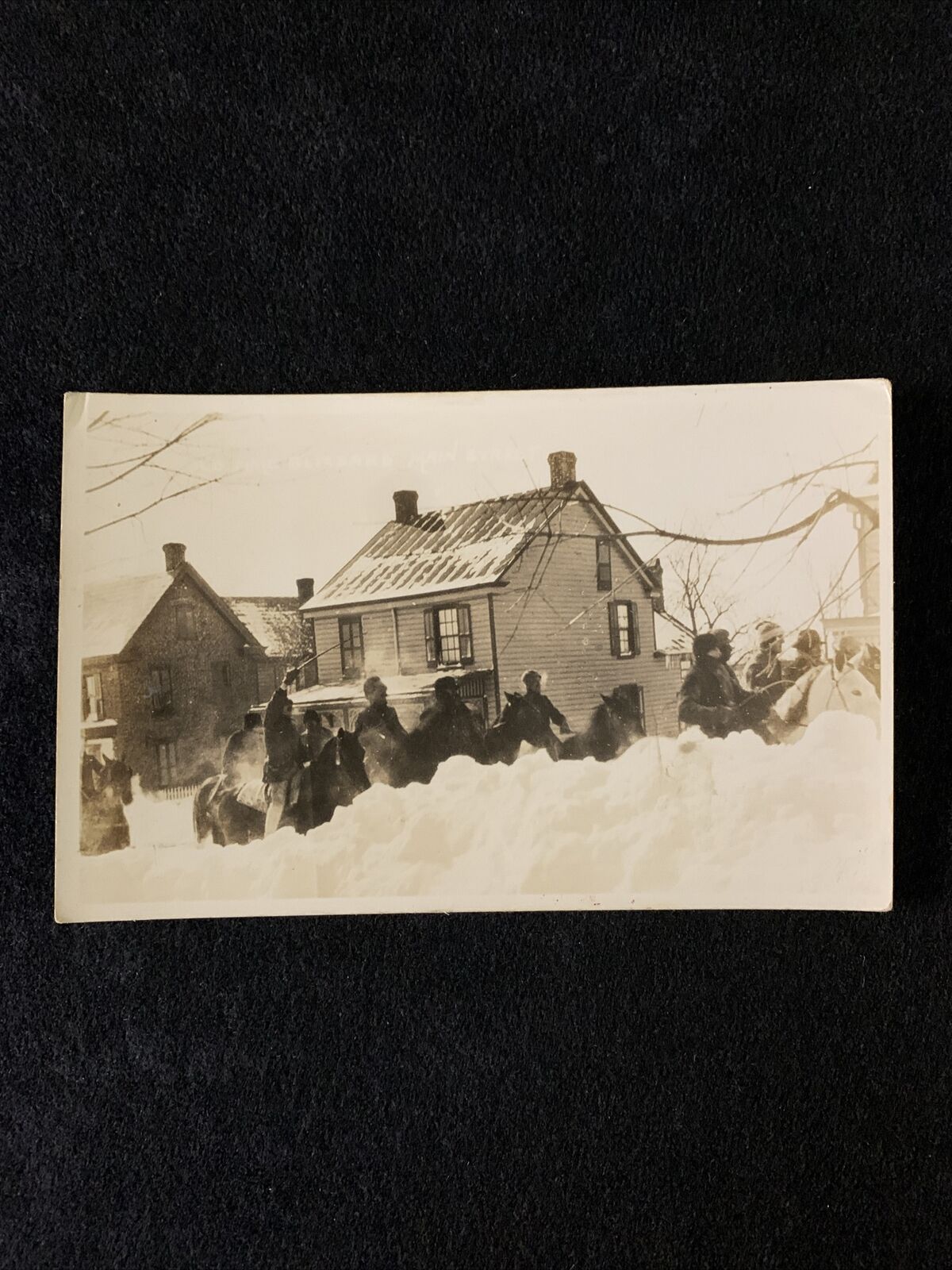 RPPC Postcard Line Of Men On Horseback In Snow Through Town c.1904-1918. Unpost