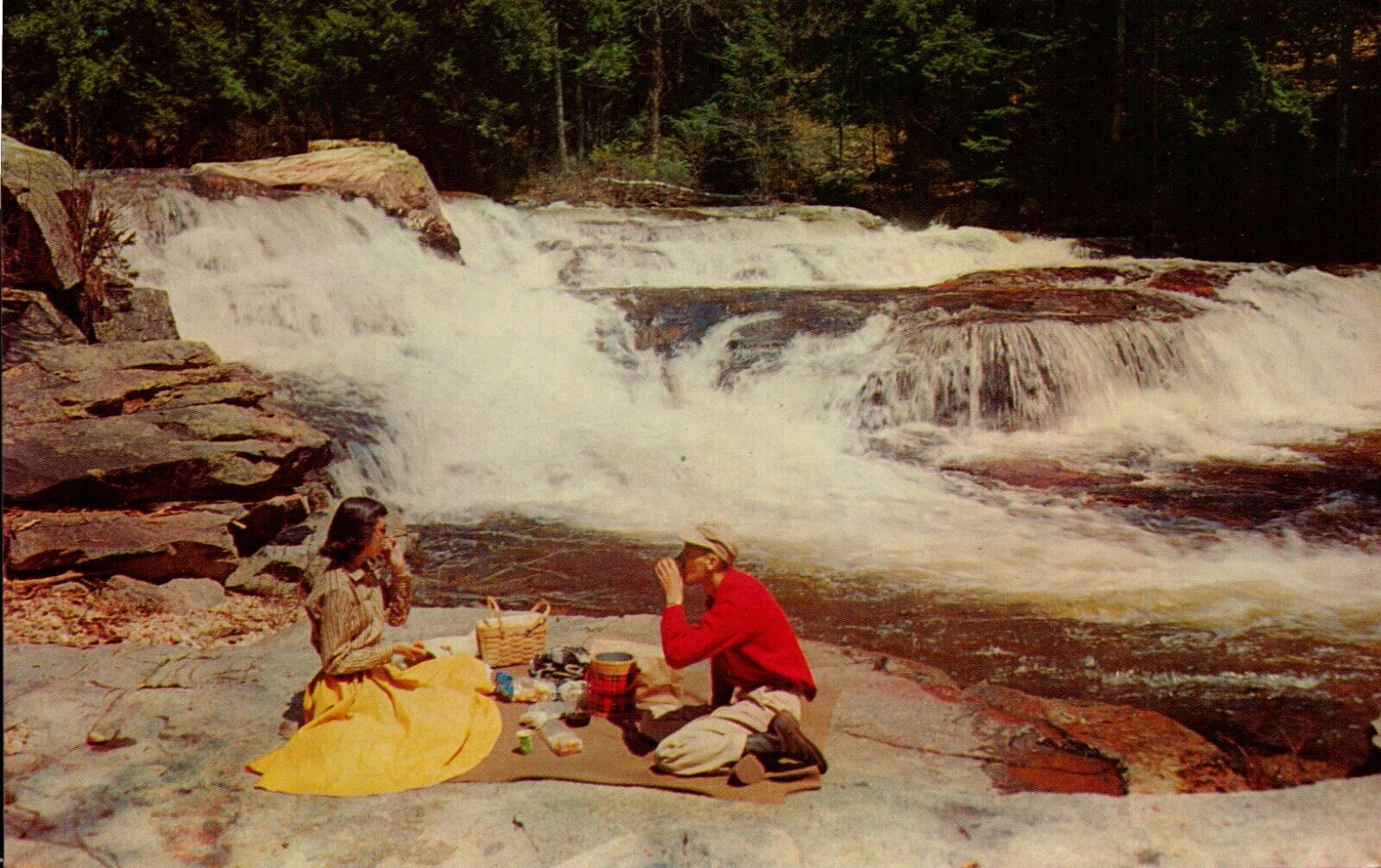 Postcard Picnicking man and woman by rock ledge rushing waters