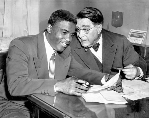 Jackie Robinson listens to Brooklyn Dodgers owner Branch Rickey as .. Old Photo