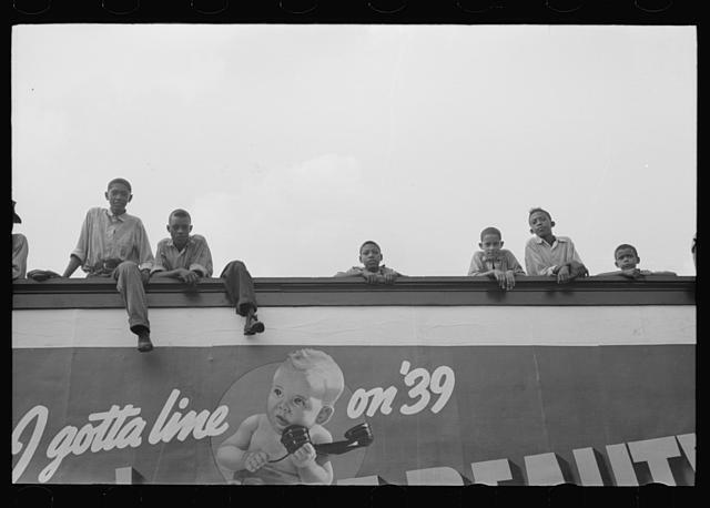 Negro boys atop billboard, National Rice Festival, Crowley, Louisiana
