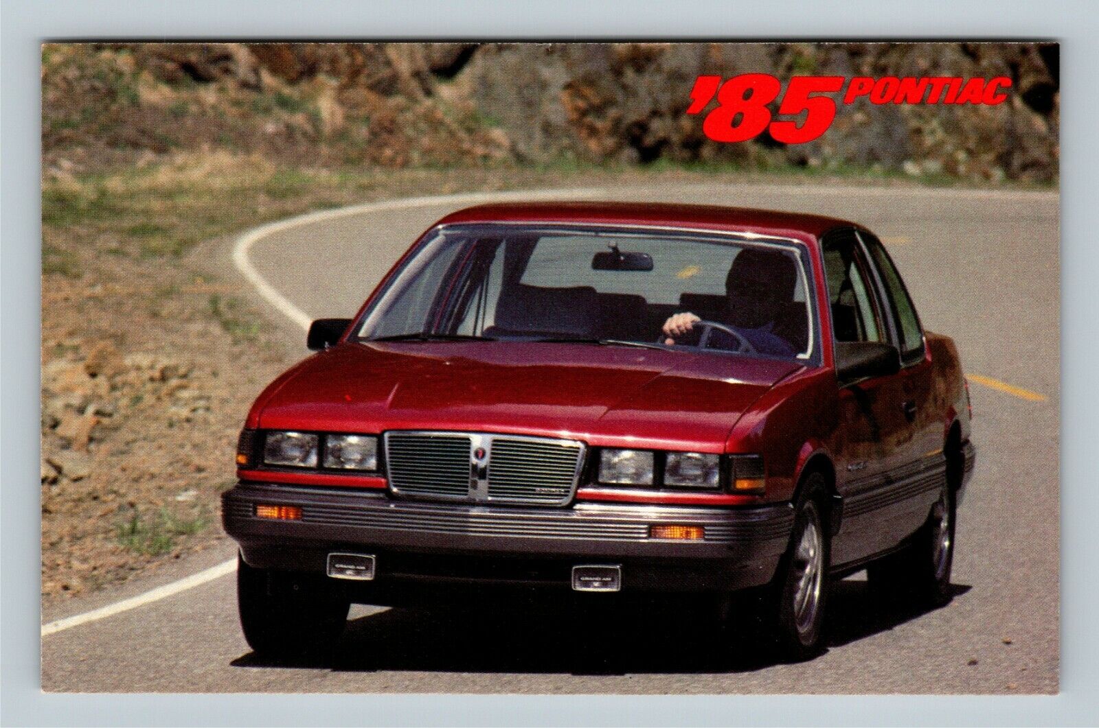 Automobile-1985 Pontiac Grand Am LE Red Vintage Postcard
