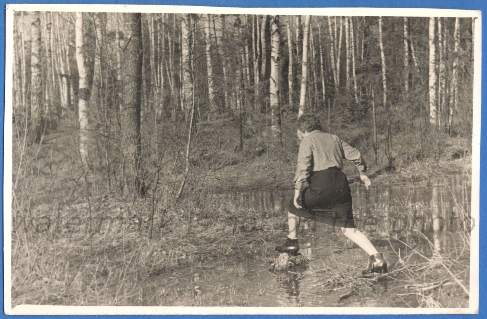 A woman crosses a small river on stones Vintage photo