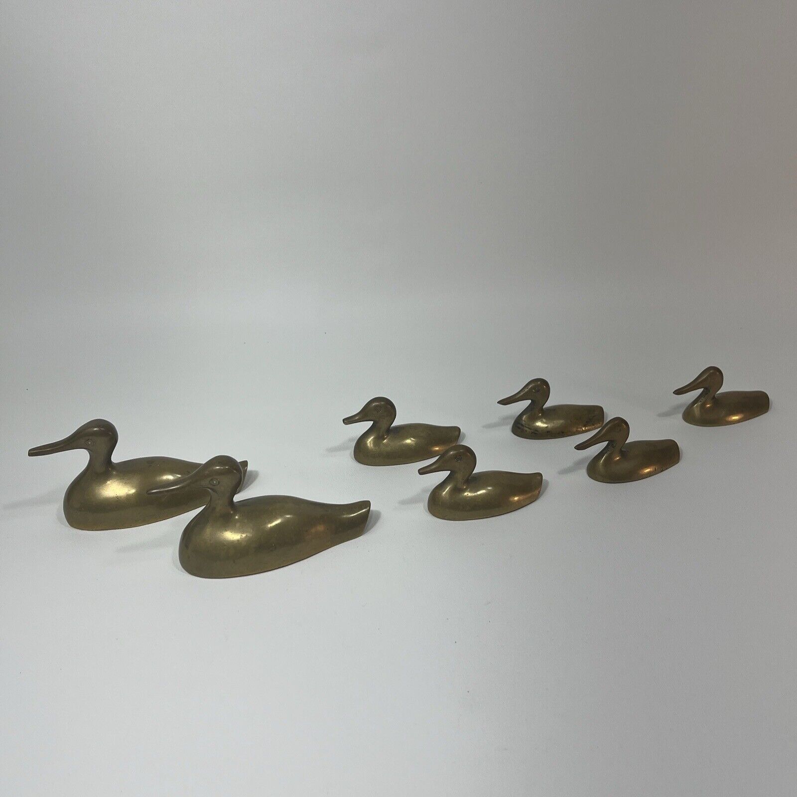 Lot of 7 Small Brass Ducks Gaggle Flock Family Swimming paddling MCM paperweight
