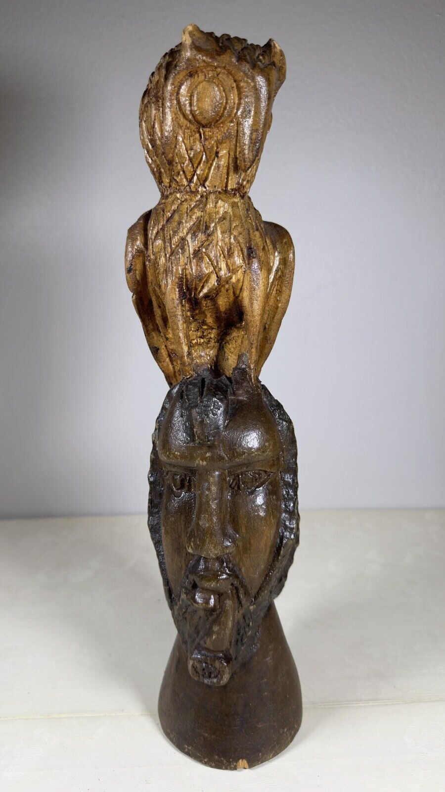 Wooden sculpture of an owl on its head